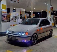 a silver car parked in front of a gas station