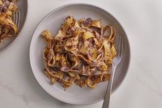 two plates filled with pasta on top of a table