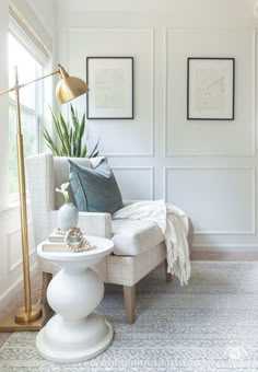 a living room with white walls and pictures on the wall