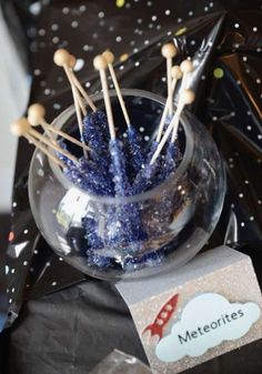 a glass bowl filled with blue and white candy sticks