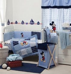 a mickey mouse crib bedding set in a child's room with blue and white decor