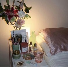 a night stand with flowers and other items on it