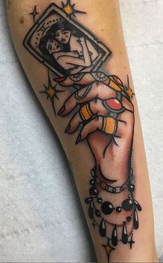 a woman's arm with a tattoo on it and a hand holding a mirror