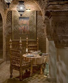 a dining room with a table and chairs next to an archway that leads into another room