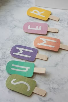 four popsicles with the word ice cream on them are lined up in different colors