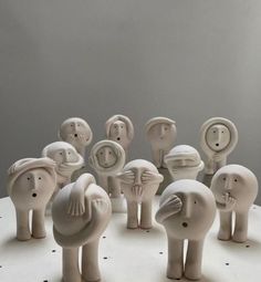 a group of ceramic elephants sitting on top of a white table