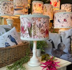 a table with many lamps on it and flowers in the basket next to each other