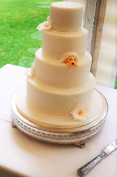 a three tiered cake sitting on top of a table next to a knife and fork