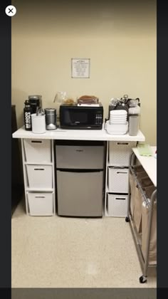 a small kitchen with white cabinets and appliances