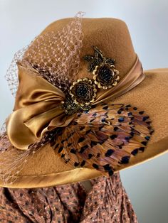 This butterscotch/camel/caramel widebrim hat is flat out fabulous! It is hand blocked over a vintage hat block and hand sewn with many tiny stitches. The crown (top) of the hat comes to a soft point and the brim has a slight down turn. Millinery wire is sewn inside of the brim edge to help the hat keep it's shape. The band and brim edge is a gorgeous hand dyed silk ribbon. It's finished with a three loop now, two pretty beaded sequin flowers, coordinating feathers and a large bow of vintage nett Brown Flat Brim Cloche Hat For Kentucky Derby, Vintage Winter Fedora For Party, Elegant Brown Cloche Hat With Curved Brim, Handmade Elegant Fedora With Curved Brim, Elegant Handmade Fedora With Curved Brim, Vintage Winter Party Fedora, Adjustable Elegant Brown Felt Hat, Vintage Fedora Top Hat For Fall, Vintage Fedora For Fall Party