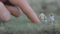 miniature people standing in the grass with their fingers on them