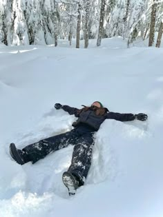 a person laying in the snow with their arms out