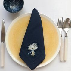 a white plate topped with a blue napkin and silverware