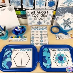 snowflakes are on display in front of the classroom's writing and crafting station