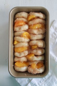 a pan filled with lots of food on top of a white tablecloth next to a napkin