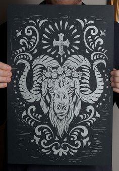 a black and white drawing of a horned animal with a cross on it's head