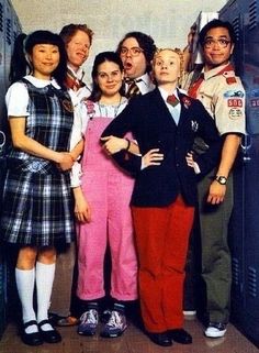 a group of people standing next to each other in front of lockers