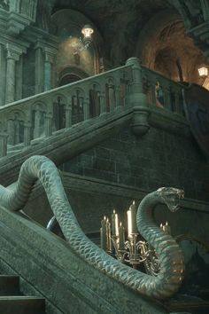 a large snake is on the stairs in a building with chandeliers and candles