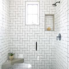 a white tiled bathroom with an open window