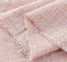 closeup of the texture of a pink and white tweed fabric with frayed edges