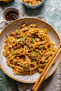 a plate full of noodles with chopsticks on the side