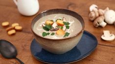 a bowl filled with soup and garnished with parsley next to some nuts