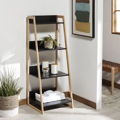 a shelf with towels, candles and other items on it in the corner of a room