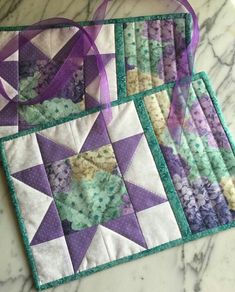 two quilted placemats sitting on top of a marble counter