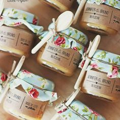 several small jars filled with honey on top of a wooden table