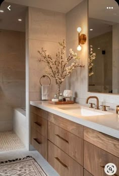 a bathroom with two sinks and a large mirror above the sink, along with a rug on the floor