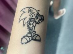 a person with a tattoo on their arm that has an image of sonic the hedgehog