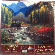 a puzzle box with a painting of a train on the tracks and mountains in the background