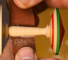 a close up of a person playing with a wooden toy guitar and an object in the background