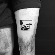 a black and white photo of a man's leg with a plane on it