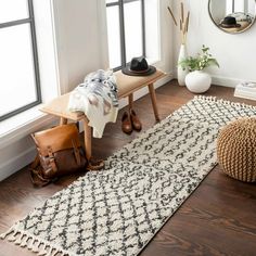 a living room with a rug, chair and mirror on the wall next to it