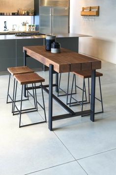 a kitchen table with four stools and a coffee cup on it in front of the counter