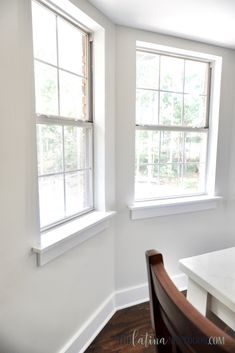 an empty room with two windows and a table