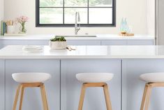 three stools are in front of the kitchen counter