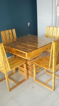 a table and chairs made out of pallet wood in a room with tile flooring