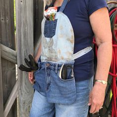 an older woman wearing overalls and holding a pair of gardening gloves in her pocket