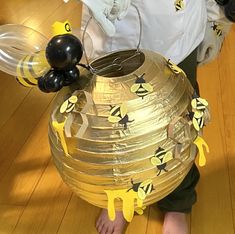 a young boy is playing with an inflatable beehive on the floor