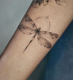 a woman's arm with a dragonfly tattoo on the left side of her arm