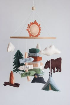 a mobile made out of felt with animals and trees hanging from it