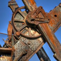 an old rusty clock is shown against a blue sky with lots of rust on it