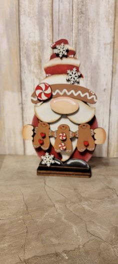 a wooden christmas tree with gingerbreads and snowflakes on it's face