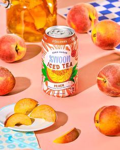 a can of swoon iced tea next to sliced peaches on a pink table