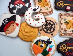 some decorated cookies are on a table with pirate themed designs and other items in the background