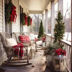 the porch is decorated for christmas with red and white plaid blankets, evergreens, potted trees, and wreaths