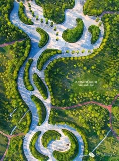 an aerial view of a river in the middle of a green area with trees and grass