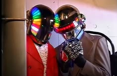 two people in suits and helmets standing next to each other